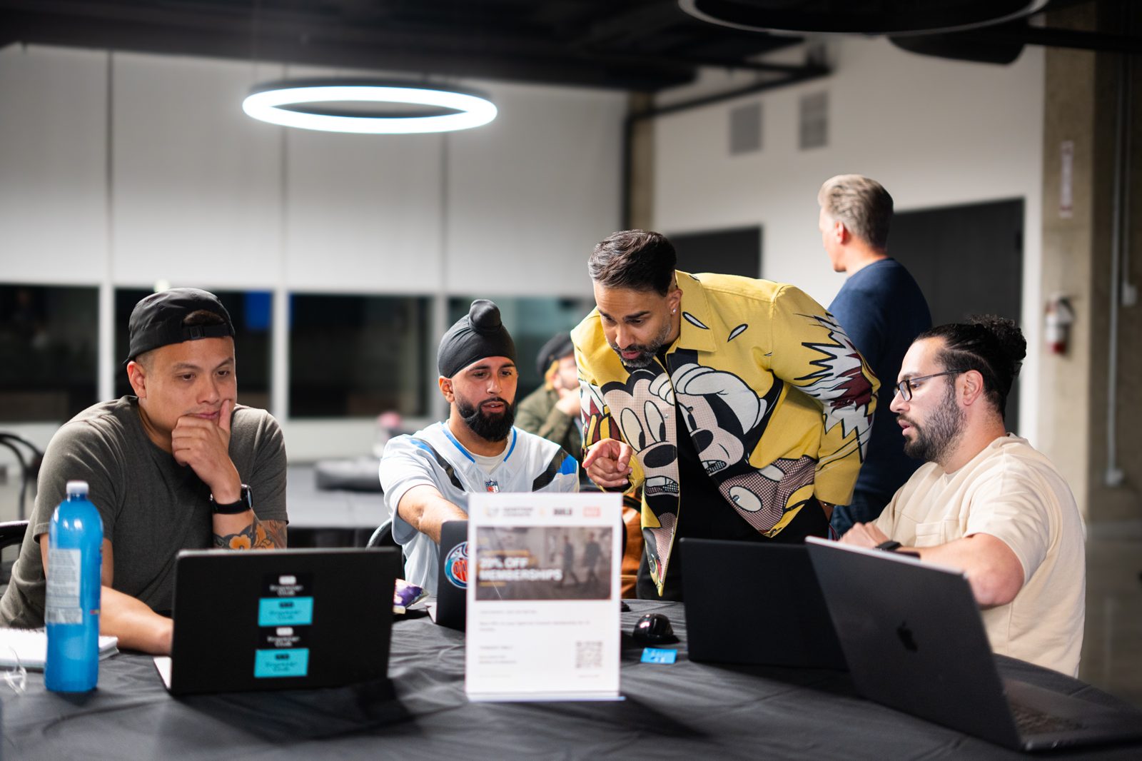 Nav working through a live build with three attendees at their laptops